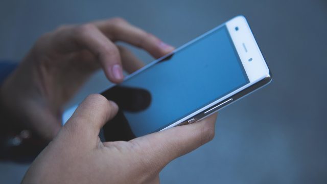 手游界面在夜间环境下自动运行副本循环，屏幕散发冷蓝色光晕